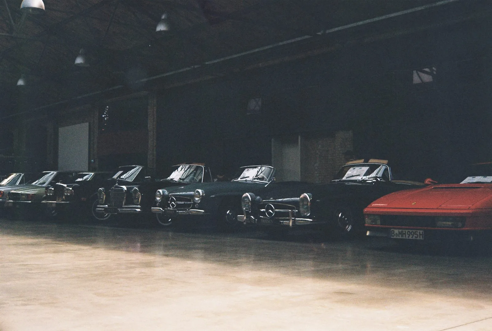 Mercedes 300SL, W113 Pagoda, and Ferrari Jalpa lined up in a warehouse