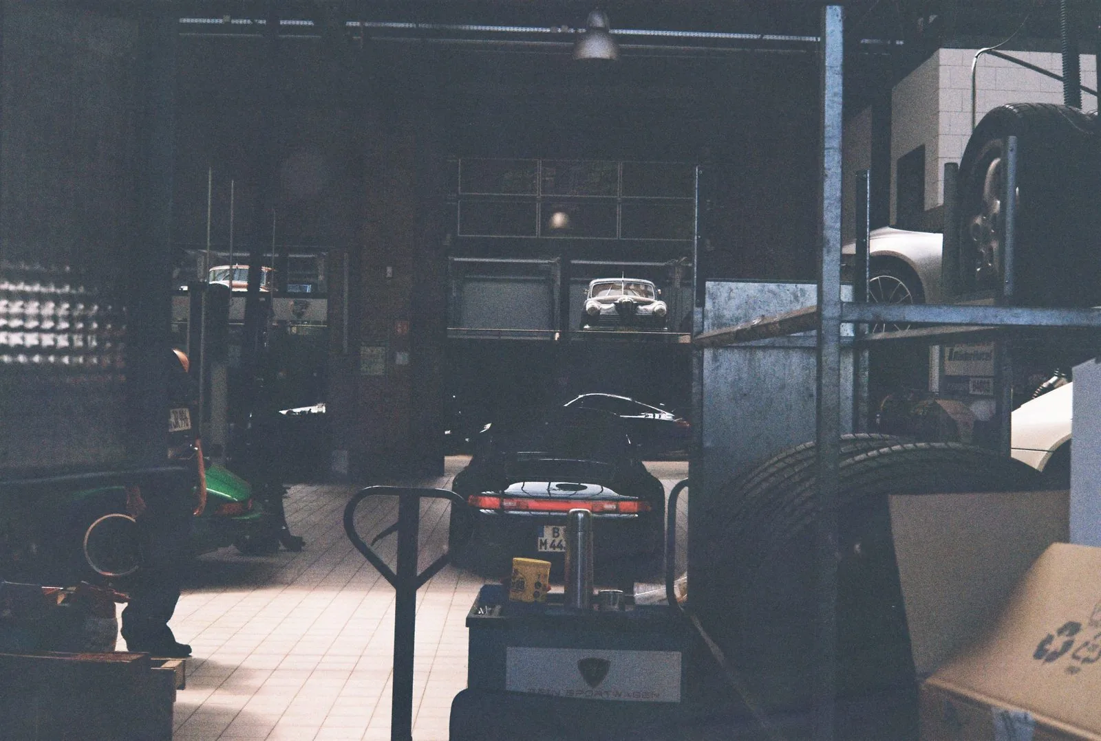 Workshop door, Porsches stacked on shelves