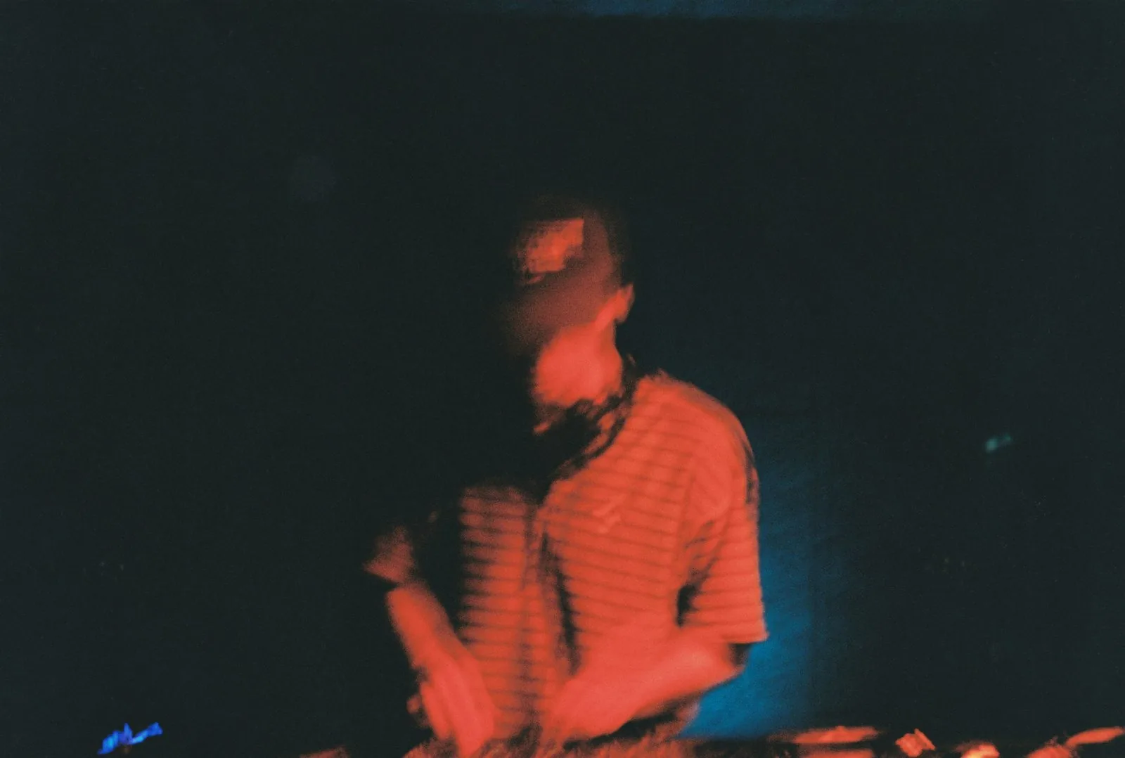 DJ mid-set under deep red stage light