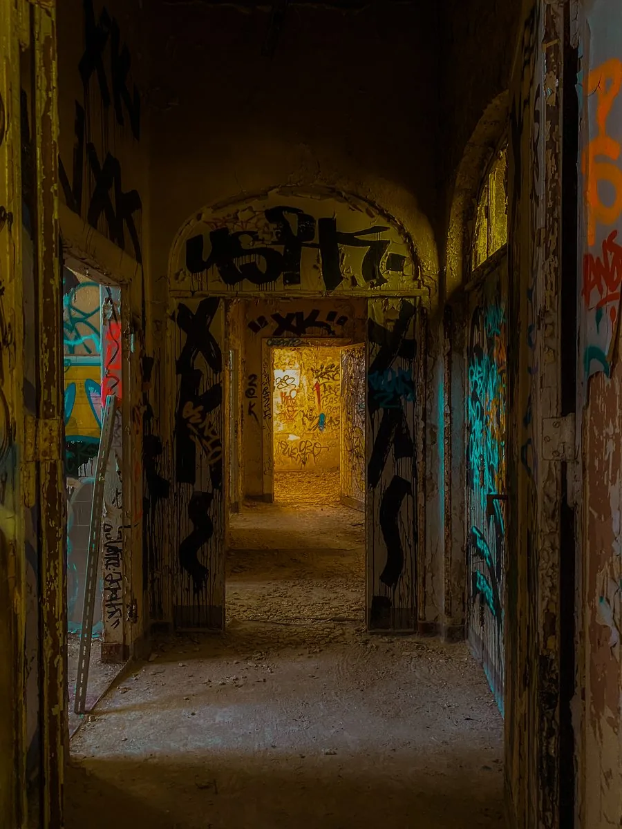 Abandoned building corridor, every surface tagged