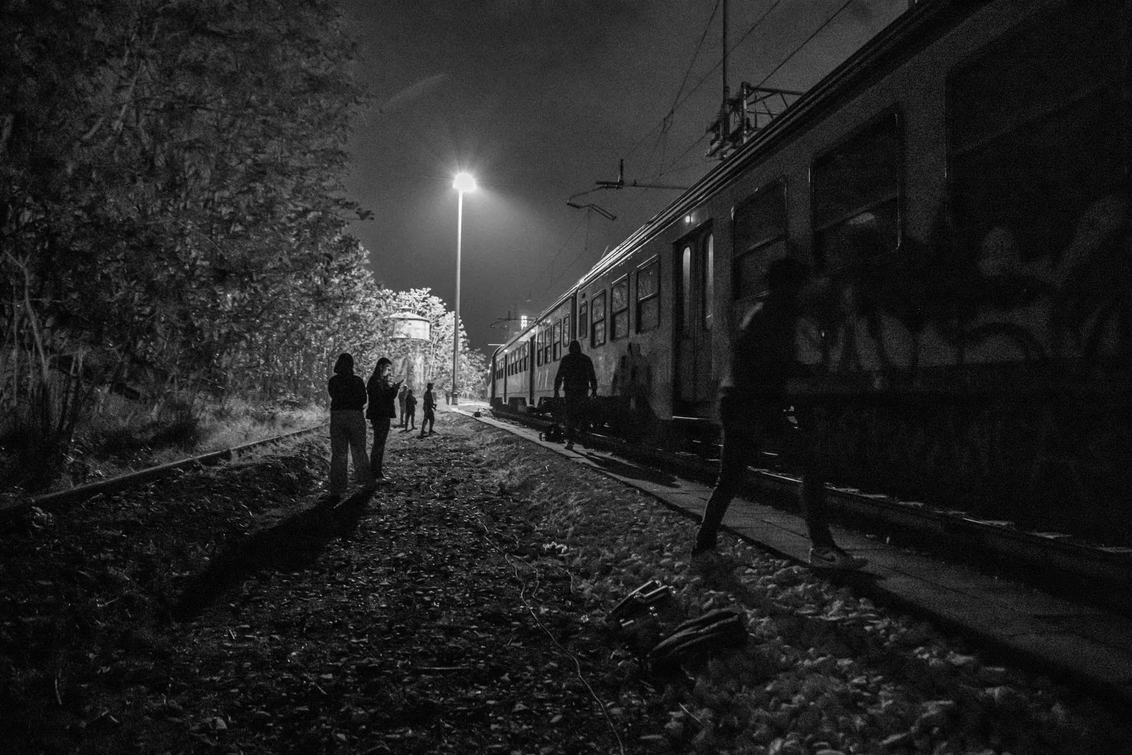 Figures along the tracks at night
